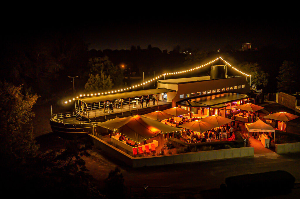 Die amSee Eventlocation bei Nacht von oben fotografiert. Erfahren Sie hier mehr über den Preis für die Locationmiete.