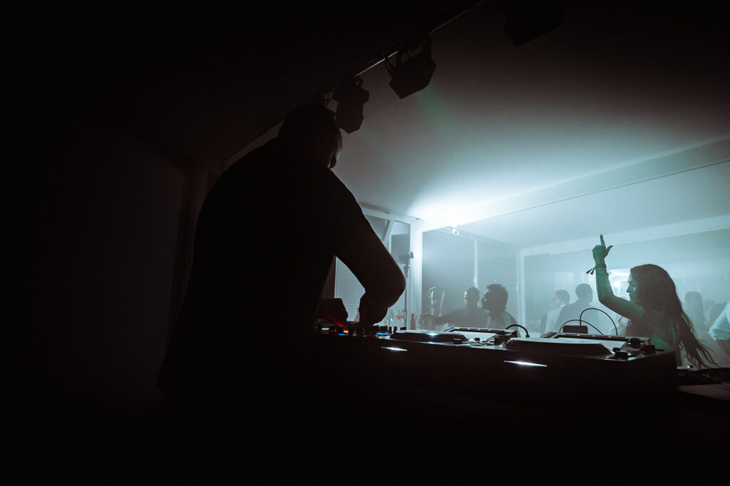 Ein DJ legt im Wintergarten des amSee auf.