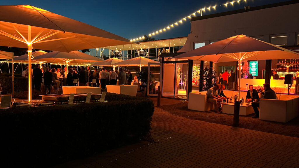 Für ein abendliches Business-Event ist der Außenbereich der Location stilvoll hergerichtet und stimmungsvoll beleuchtet.