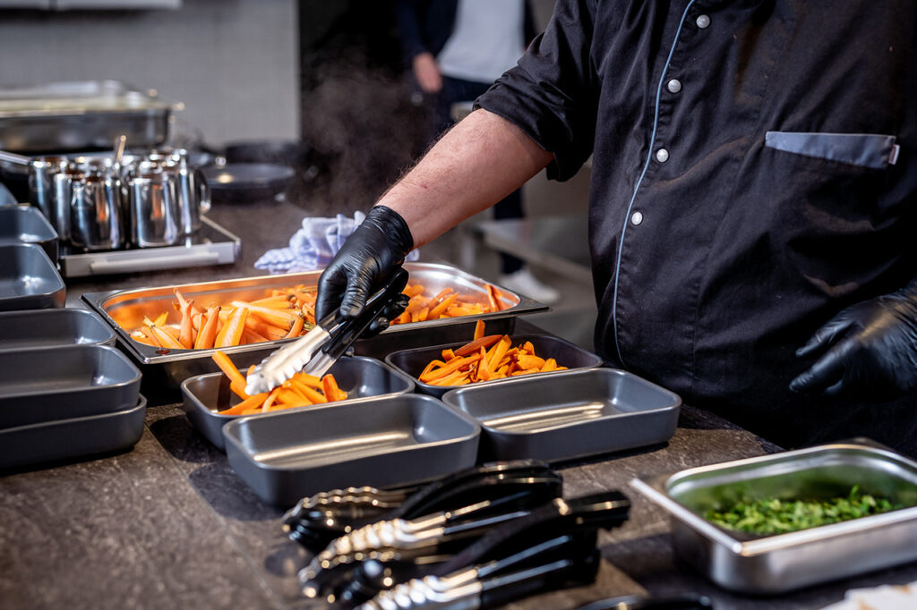 Einer der Köche des Teams beim Anrichten von Gemüse in der Küche