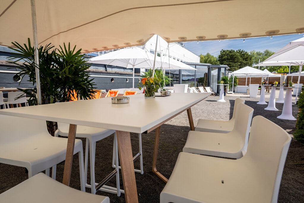 Sitzgruppe unter einem großen Sonnensegel vor dem Bug der amSee Eventlocation.