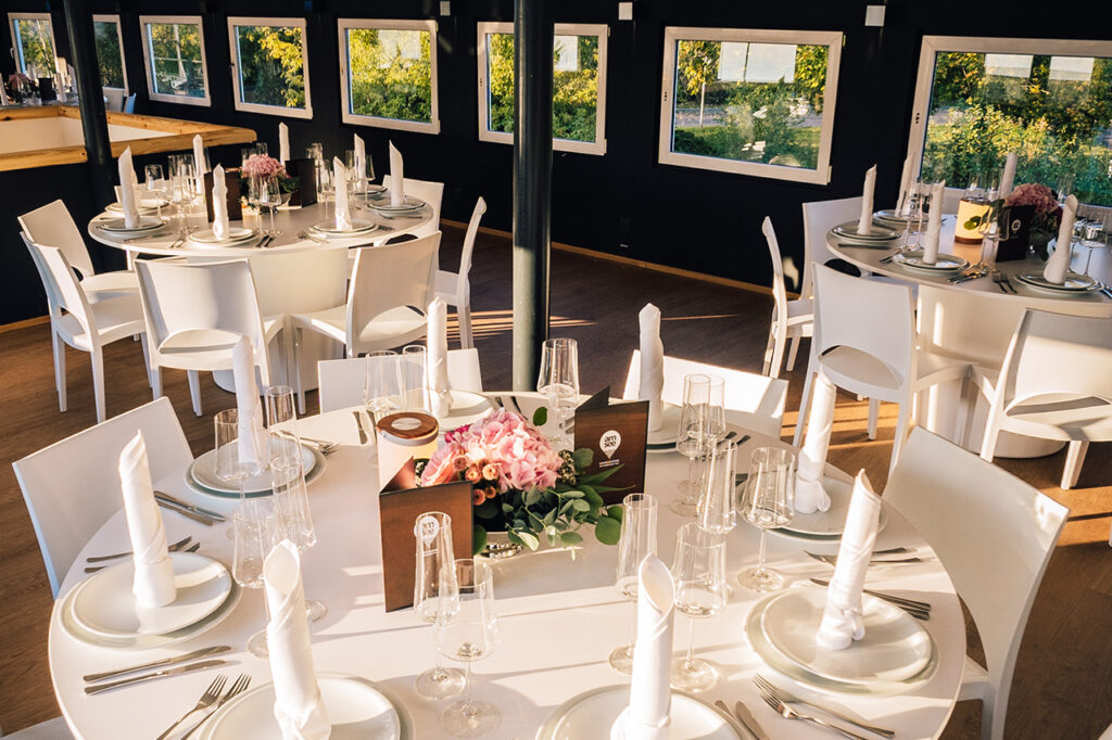 Ostseite des Oberdecks mit festlichen weißen Möbeln und dem Treppenaufgang im Hintergrund.