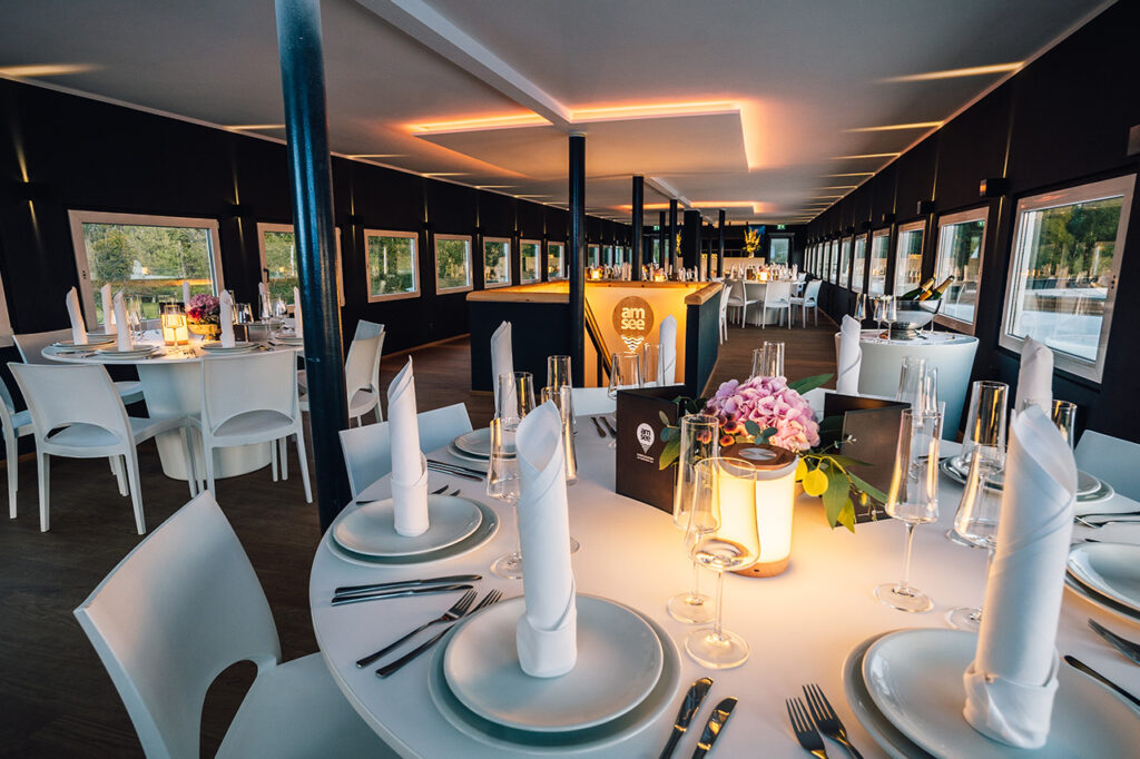 Das Oberdeck der amSee Eventlocation, eingerichtet mit weißem Bankettmobiliar.